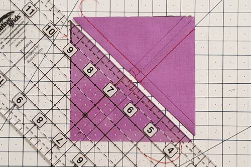 Step 3 3 patch quarter square triangles:  Using a rotary cutter and quilting ruler, cut the squares in half by cutting diagonally from one corner to corner.