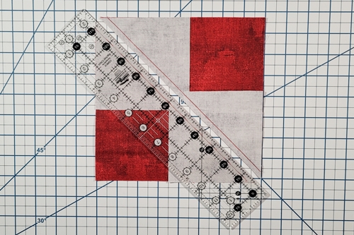 Step 4: 4 Flying Geese At Once: Place the 1/4 inch measurement line of a quilting ruler along the length of one of the seams and make a cut. Step 4: 4 Flying Geese At Once: Place the 1/4 inch measurement line of a quilting ruler along the length of one of the seams and make a cut.