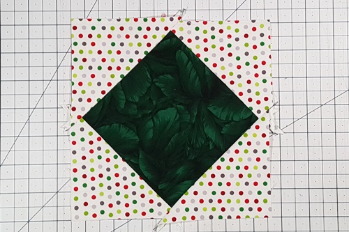 You have now added corner triangles for setting blocks on point and the block is now a square in a square block. Now it's time to trim or square up the block. You have now added corner triangles for setting blocks on point and the block is now a square in a square block. Now it's time to trim or square up the block.