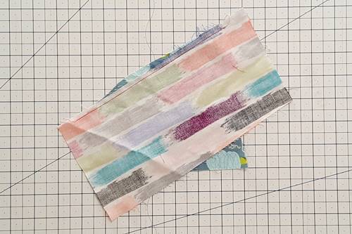 Step 2 Crazy Quilt Block: Select a second scrap piece and stitch it to the first.