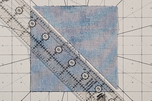 Duck Tracks Quilt Block Tutorial Step 2: place a quilting ruler on the left leaning (\) diagonal axis and use a rotary cutter to make a cut along it.