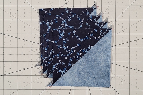 Duck Tracks Quilt Block Tutorial Step 4: Fold Fabric B back to open the HST with fabrics right side up. Press the seams toward the darker fabric.