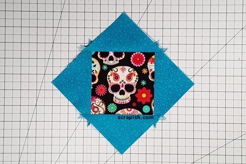 Picture of an Economy Quilt Block or a square in a square unit that needs to be trimmed. Economy Quilt Block: You now have a square in a square unit that needs to be trimmed.