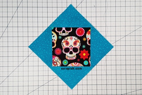 Picture of what the first round of an economy quilt block looks like. The first round of a trimmed economy quilt block looks like a square in a square unit.