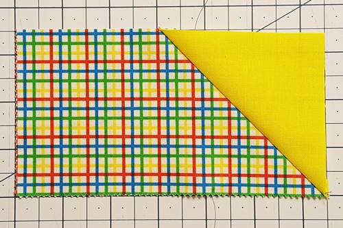 Step 5 Flip the triangle face up. Press the seam toward the triangle of the flying geese unit.