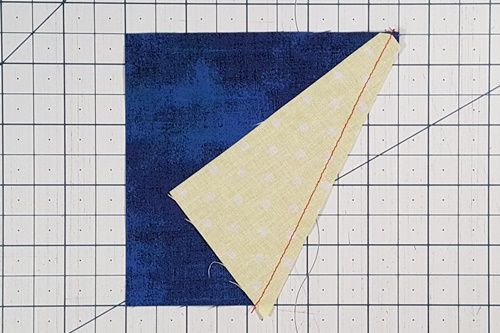 Step 2e Galaxy Star Quilt Block Variation Pattern: Stitch the side triangle to the remaining portion of the square. Step 2e Galaxy Star Quilt Block Variation Pattern: Stitch the side triangle to the remaining portion of the square.