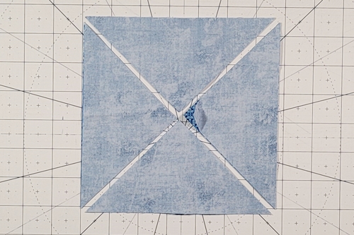Hope of Hartford Quilt Block Step 2: Use a rotary cutter to make a cut from corner to corner along both diagonal axes.