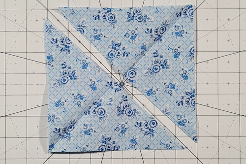 Hope of Hartford Quilt Block Step 4: 
Place both Fabric A HST squares, right sides up, on top of one another. Cut in half along left leaning (\) diagonal axis. Press in half along diagonal edge.