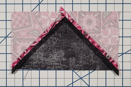 Picture of the backside of a flying geese unit with both seams pressed open.