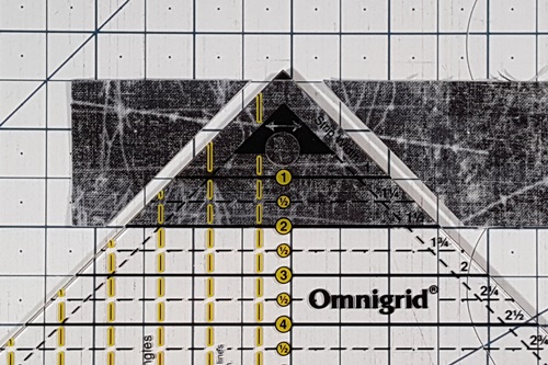 How To Use A Quarter Square Triangle Ruler: align bottom of blackened or highlighted triangle along top edge of strips and ruler's measurement line along bottom. How To Use A Quarter Square Triangle Ruler: align bottom of blackened or highlighted triangle along top edge of strips and ruler's measurement line along bottom.