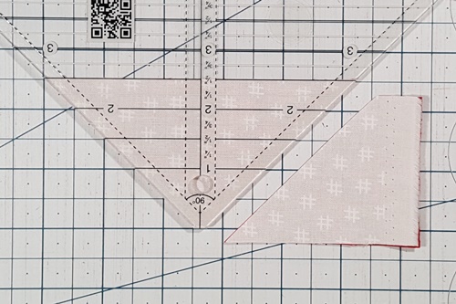 How To Use A Quarter Square Triangle Ruler: Rotate the fabric and the ruler 180 degrees and make the second cut. How To Use A Quarter Square Triangle Ruler: Rotate the fabric and the ruler 180 degrees and make the second cut.