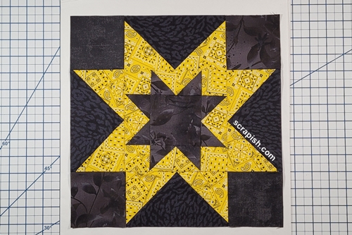 Picture of a radiating (expanding) sawtooth star quilt block stitched together.