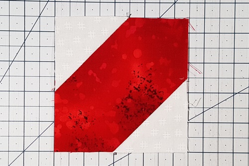 Step 4d Square in a Square: Flip what remains of the small squares right side up to reveal the new corners which are now triangles. Press the seams towards the triangles. Step 4d Square in a Square: Flip what remains of the small squares right side up to reveal the new corners which are now triangles. Press the seams towards the triangles.