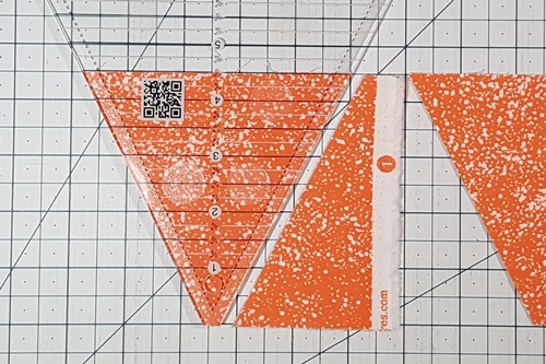 Step 9 Triangle in a Square: rotate fabric 180 degrees so uncut side is on right. Rotate ruler 180 degrees with tip at bottom of strip and measurement line at top of strip. Make a cut. Step 4 Triangle in a Square: rotate fabric 180 degrees so uncut side is on right. Rotate ruler 180 degrees with tip at bottom of strip and measurement line at top of strip. Make a cut.